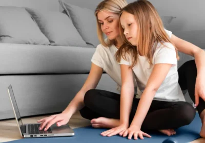 Parent and child reviewing online forms for sports physical while preparing for in-person exam at home.